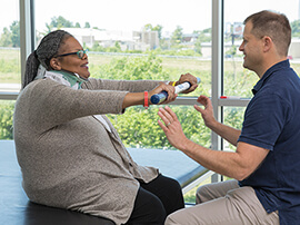 Spinal cord patient does exercises with therapist. 