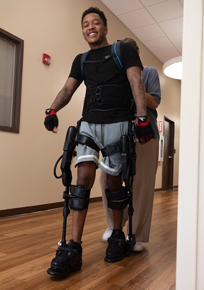 Photo of Z McKinney using an exoskeleton to walk at Baylor Scott & White Institute for Rehabilitation. 