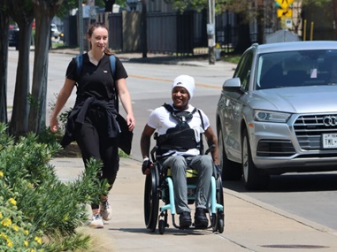 Photo of Z McKinney walking with a therapist during a community outing at Baylor Scott & White Institute for Rehabilitation.