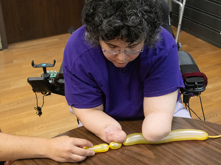 Photo of Francis Zalace demonstrating balloon art at Baylor Scott & White Institute for Rehabilitation - Dallas. 