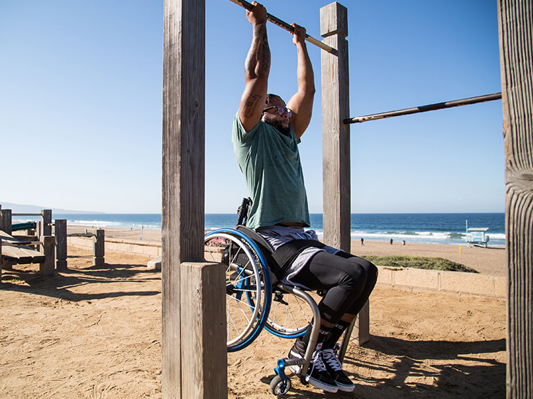 Leonard Harmon, who suffered a spinal cord injury, does pull ups while buckled to his wheelchair.