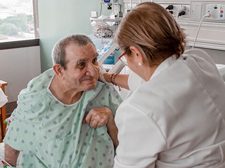 Therapist places hand on patient's shoulder.