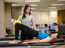 A female patient doing pelvic exercises with a physical therapist.