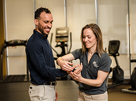 A male patient doing hand exercises with a female physical therapist.