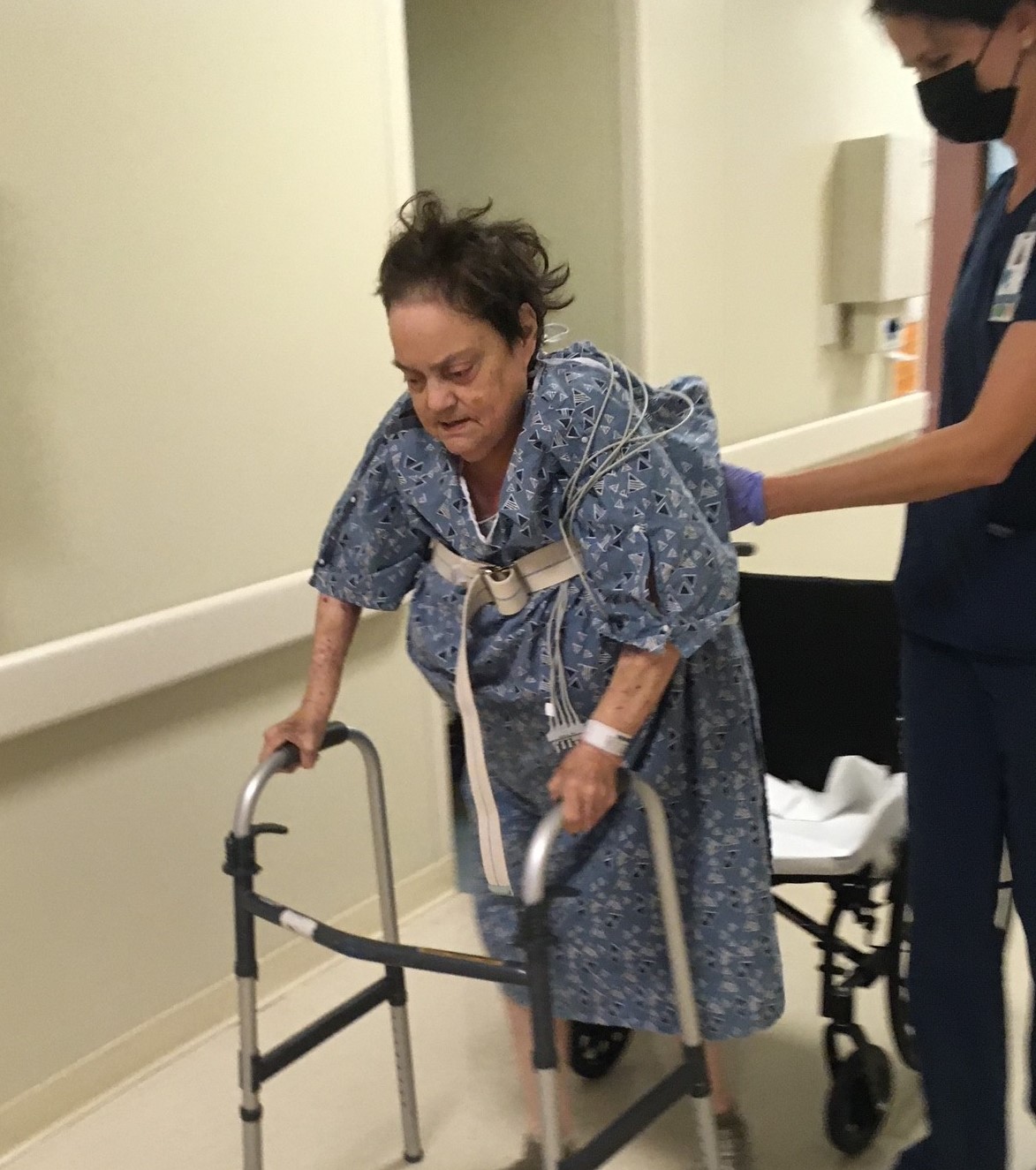 Margaret Shaw balancing on her walker with the help of her therapist in the hospital. 
