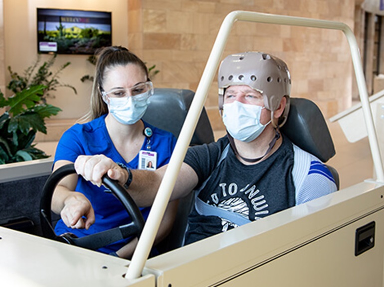Brain injury patient works with therapist to learn to drive again.
