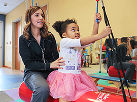 Little girl does exercises with pediatric therapist.