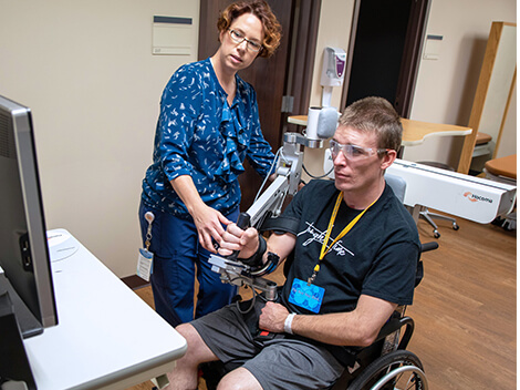 Brain injury patient uses technology with therapist to recover.