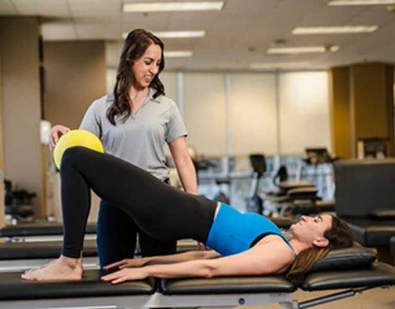 A female patient doing pelvic exercises with her physical therapist.