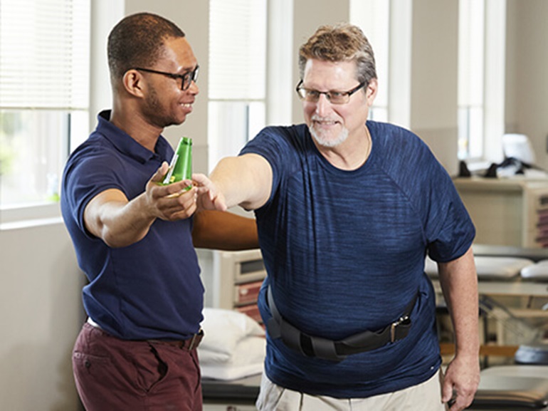A brain injury patient working with a physical therapist on neurological exercises.