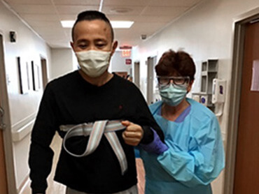photo of Lei Zhang walking with a therapist