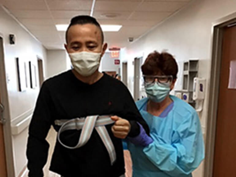 photo of Lei Zhang walking with a therapist