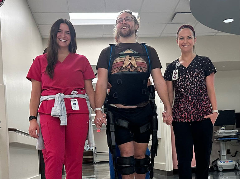 Michael Scott walking with two nurses during a therapy session.
