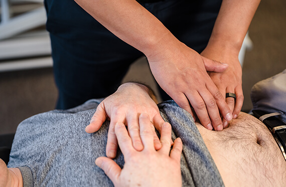 Close up of a patient's stomach while a therapist is touching their stomach