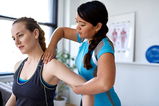 Therapist helping patient do arm stretches.
