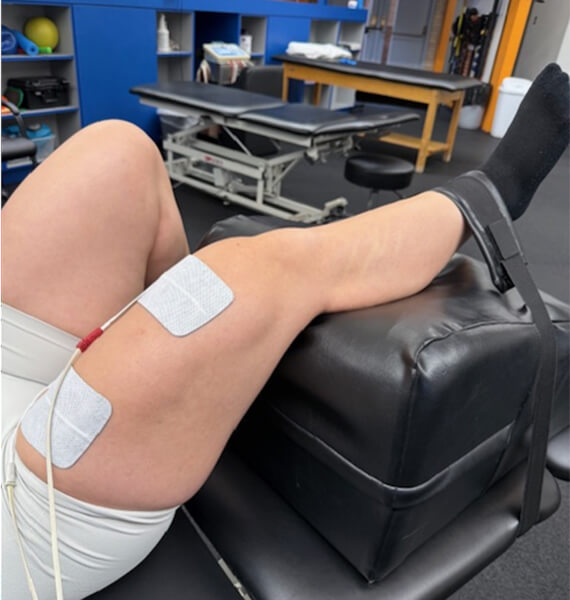 Close up of a patient's knee with electrode patches on