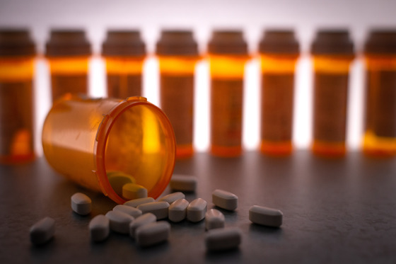 A dark image of opioid bottles lined up.