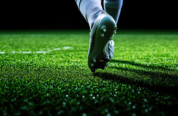Close up of cleats on a field walking away from the camera 